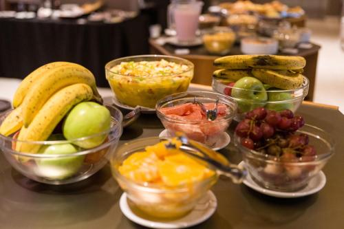 a table topped with bowls of fruits and vegetables at Hotel Treinta-Seis in Mar del Plata