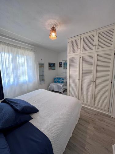 Un dormitorio con una gran cama blanca y una ventana en La casa di Camilla en Cannigione