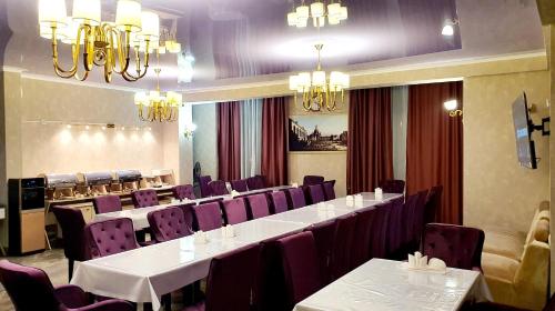 a dining room with white tables and purple chairs at LAMIYA Aparts Hotel in Almaty