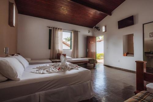 a large bedroom with two beds and a window at Hotel Fazenda Vale Amanhecer in Igarapé