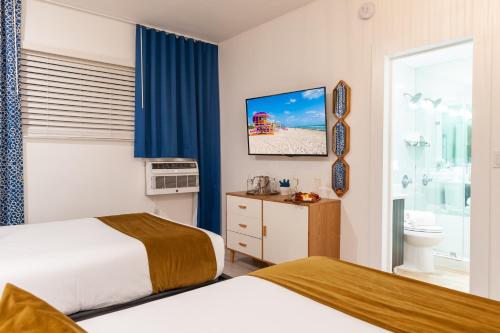 a hotel room with two beds and a bathroom at Catalina Hotel & Beach Club in Miami Beach