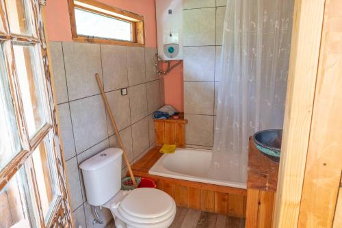 a bathroom with a toilet and a bath tub at Casita del Arbol Santa Clara in San Carlos de Bariloche