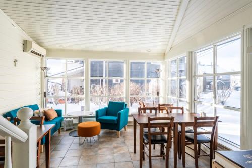 um quarto com uma mesa, cadeiras e janelas em Mo Gjestegård em Mo i Rana