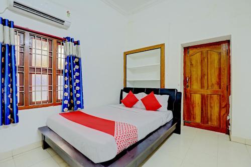 a bedroom with a bed and a wooden door at OYO K B Residency in Chennai