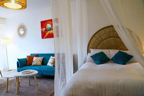 - une chambre avec un lit et un canapé bleu dans l'établissement Douceur Angevine, à Angers