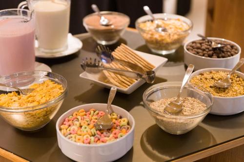a table topped with bowls of different types of food at Hotel Treinta-Seis in Mar del Plata