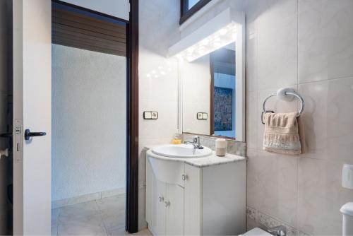 bagno bianco con lavandino e specchio di Apartment Oiza Canopus Sea Views at the beach a Alcudia