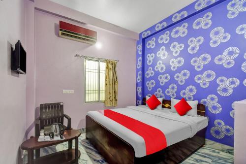 a bedroom with a bed and a blue and white wall at Hotel O Heritage Inn in Cuttack