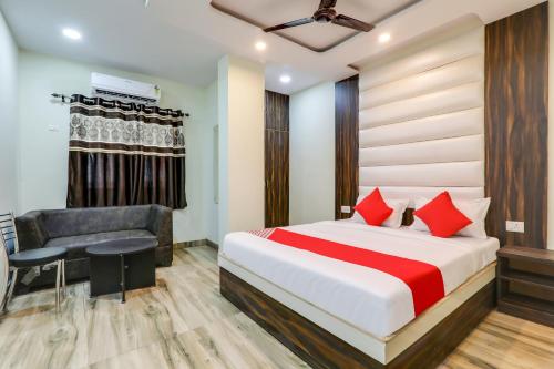 a hotel room with a bed and a chair at 75217 Hotel Navya Grand in Gulzārbāgh