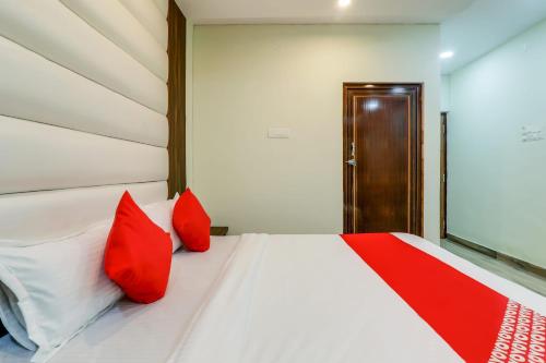 a bedroom with a bed with red pillows on it at 75217 Hotel Navya Grand in Gulzārbāgh