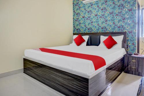 a bedroom with a bed with red pillows at Flagship Sk Brother Hotel in Patna