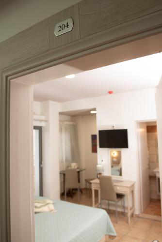 a room with a bed and a dining room with a table at Tsaner Apartment and Rooms in Matala
