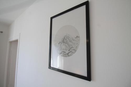 a mirror on a wall with a picture on it at Grand Parking gratuit, De 1 à 4 personnes, Tout équipé, Netflix, Amazon Prime Gratuits et Illimités, Matelas Emma, Lave Linge, Vue sur la Vallée, RDC in Pont-Hébert