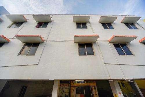 a tall white building with windows on the side of it at SPOT ON 75475 Cn Guest House in Chennai