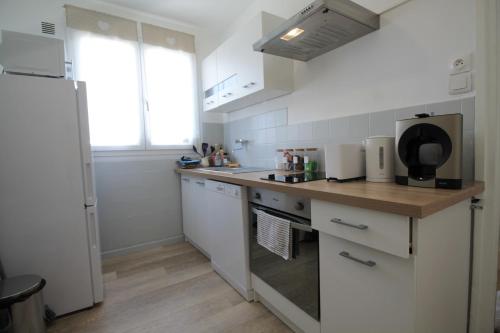 a kitchen with white cabinets and a counter top at Grand Parking gratuit, De 1 à 4 personnes, Tout équipé, Netflix, Amazon Prime Gratuits et Illimités, Matelas Emma, Lave Linge, Vue sur la Vallée, RDC in Pont-Hébert