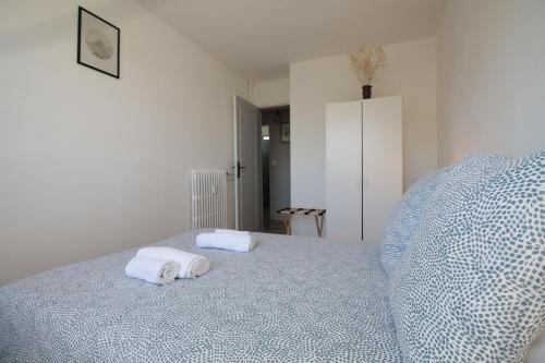 a white bedroom with two towels on a bed at Grand Parking gratuit, De 1 à 4 personnes, Tout équipé, Netflix, Amazon Prime Gratuits et Illimités, Matelas Emma, Lave Linge, Vue sur la Vallée, RDC in Pont-Hébert