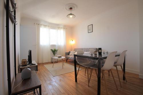 a living room with a dining table and a living room with a couch at Grand Parking gratuit, De 1 à 4 personnes, Tout équipé, Netflix, Amazon Prime Gratuits et Illimités, Matelas Emma, Lave Linge, Vue sur la Vallée, RDC in Pont-Hébert