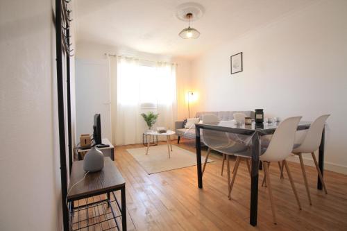 a dining room and living room with a table and chairs at Grand Parking gratuit, De 1 à 4 personnes, Tout équipé, Netflix, Amazon Prime Gratuits et Illimités, Matelas Emma, Lave Linge, Vue sur la Vallée, RDC in Pont-Hébert