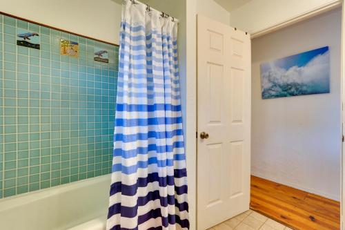 a bathroom with a blue and white shower curtain at Breezy Kailua-Kona Bungalow with Lanai and Ocean View! in Kailua-Kona