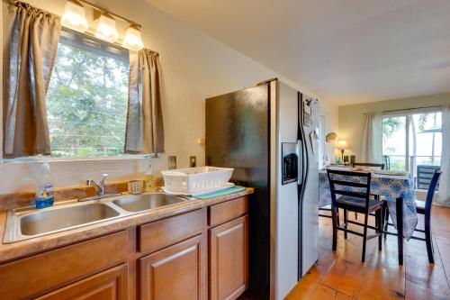 a kitchen with a sink and a refrigerator at Breezy Kailua-Kona Bungalow with Lanai and Ocean View! in Kailua-Kona