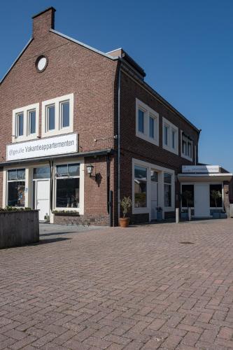 a brick building with a clock on the side of it at @ geulle in Guelle