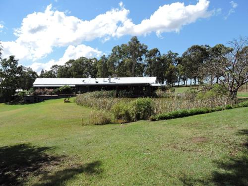 a building in the middle of a field at Hermitage Lodge in Pokolbin