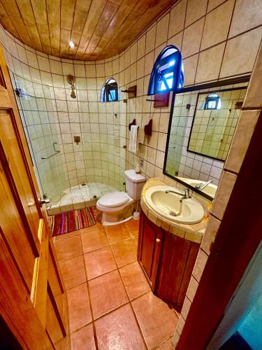 ein Badezimmer mit Waschbecken, Toilette und Spiegel in der Unterkunft Pacifica Surf Studios in Playa Santa Teresa
