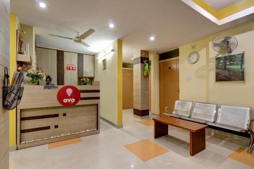 a lobby with a waiting room with chairs and a clock at OYO Hotel Satguru in Jamshedpur