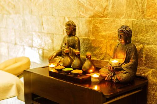 two statues sitting on a table with candles at Crowne Plaza Ahmedabad City Centre by IHG in Ahmedabad