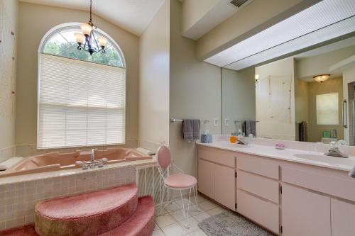 uma casa de banho com uma banheira rosa e um lavatório. em Crystal River Vacation Rental on Canal! em Crystal River