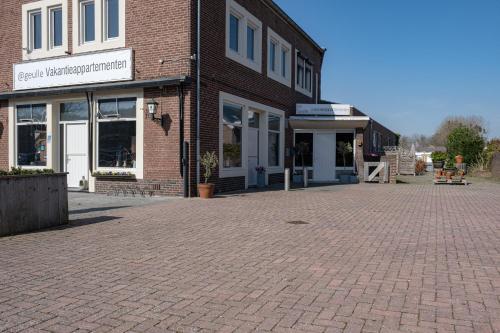 een bakstenen parkeerplaats voor een bakstenen gebouw bij @ geulle in Guelle