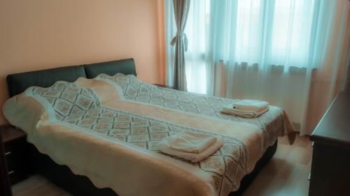 Una cama con toallas encima en una habitación en Little Star Apartment, en Oradea