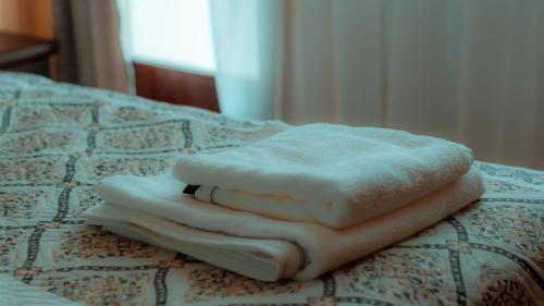 una pila de toallas sentadas encima de una cama en Little Star Apartment, en Oradea