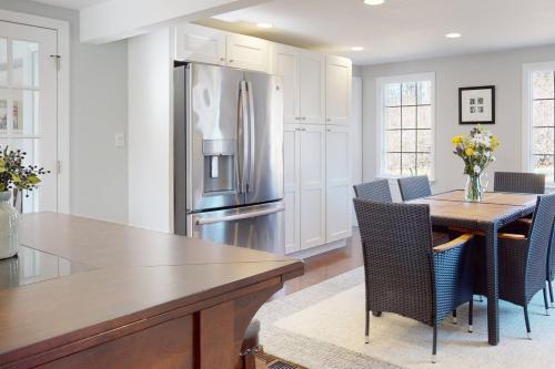 a kitchen with a table and a stainless steel refrigerator at White Oaks in Branford