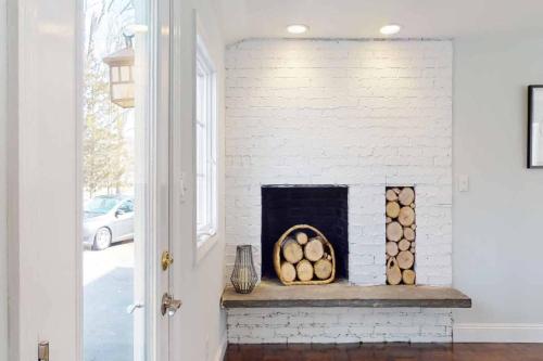 a white brick fireplace with logs in a room at White Oaks in Branford