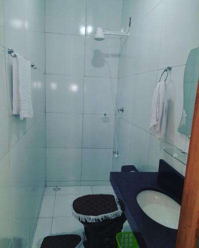 a white bathroom with a sink and a shower at Casa Temporada, jequia in Jequia da Praia