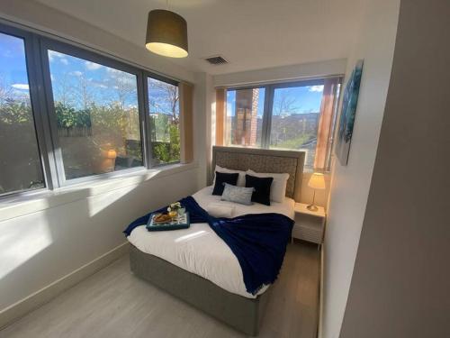 a bedroom with a bed in a room with windows at Luxury 2 Bedroom Charter House in Milton Keynes