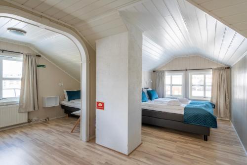 a bedroom with a large bed with blue sheets at Mo Gjestegård in Mo i Rana