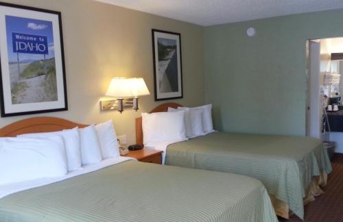 a hotel room with two beds and a lamp at Motel West in Idaho Falls