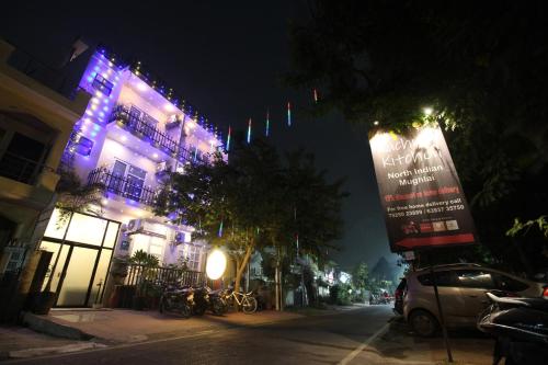 HasanganjTownhouse Kachnar House Vikas Nagar的城市街道,晚上有紫色灯的建筑