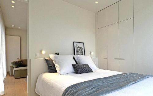 ein Schlafzimmer mit einem großen Bett mit weißer Bettwäsche in der Unterkunft Zoute - Lovely ground floor app. in Knokke-Heist