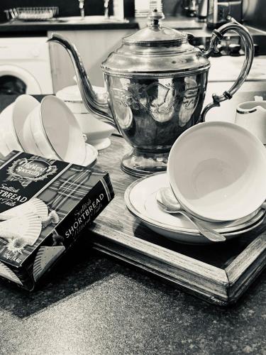 a tea pot and plates and a book on a kitchen counter at Mulberry in Nairn