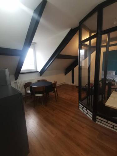 - une salle à manger mansardée avec une table et des chaises dans l'établissement Appartement entier à Sevran, à Sevran