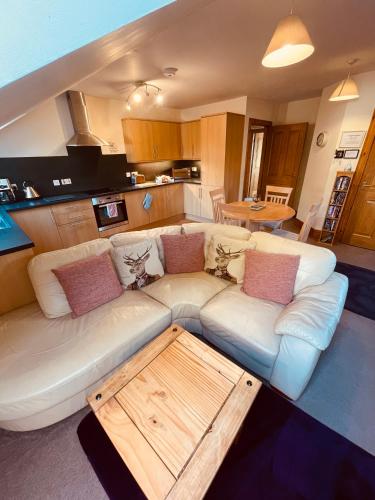 a living room with a white couch and a table at Mulberry in Nairn