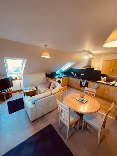 a living room with a table and a couch at Mulberry in Nairn