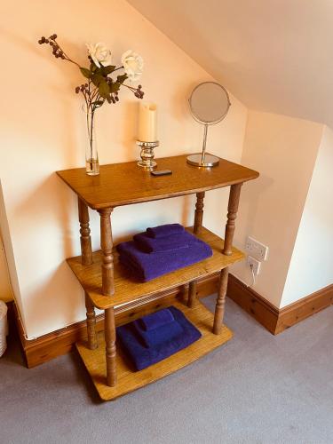 a wooden table with three blue towels and a mirror at Mulberry in Nairn