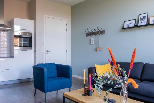 a living room with a blue couch and a table at @ geulle in Guelle