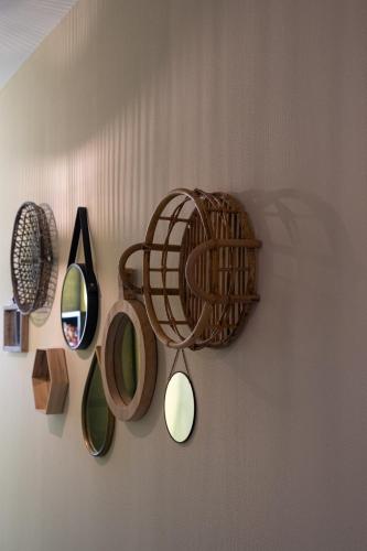 a wall with a rack of mirrors and a basket at @ geulle in Guelle