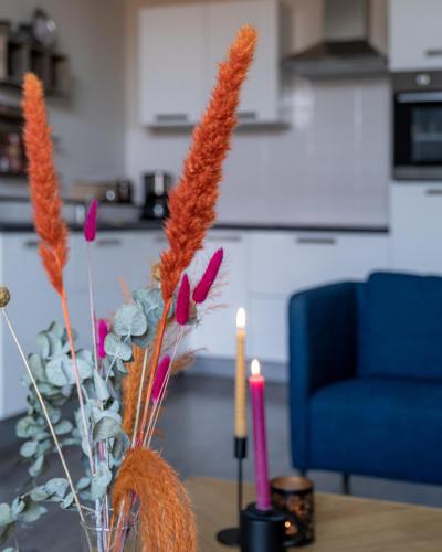 a vase with flowers and two candles on a table at @ geulle in Guelle