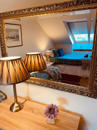 a bedroom with a mirror and a bed and a table at Mulberry in Nairn
